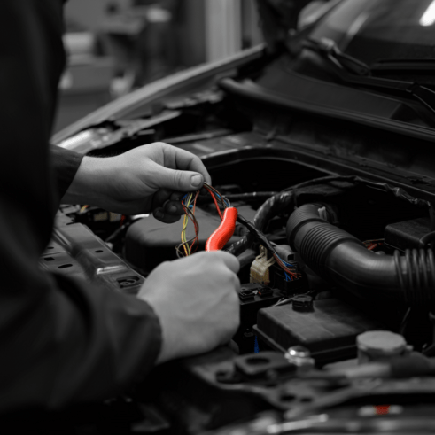 Technician working on vehicle electrical systems